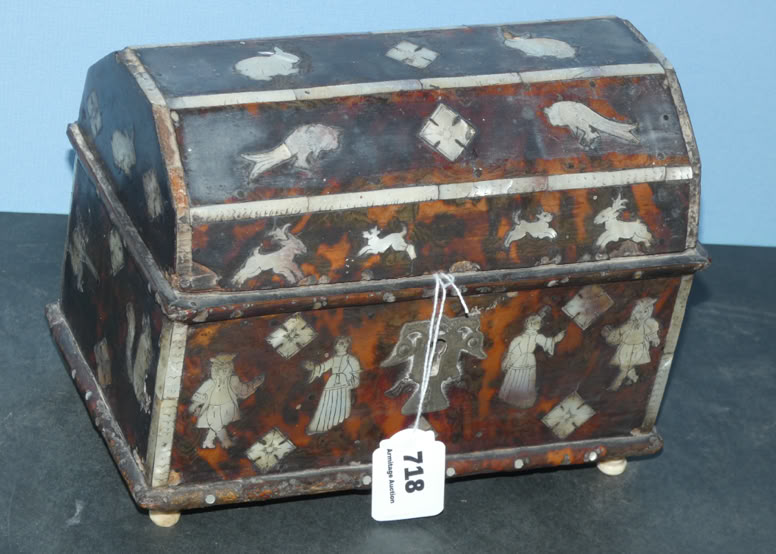 A decorative wooden chest with a domed lid, featuring inlaid designs of birds and figures, and a tag labeled "218" attached to it.
