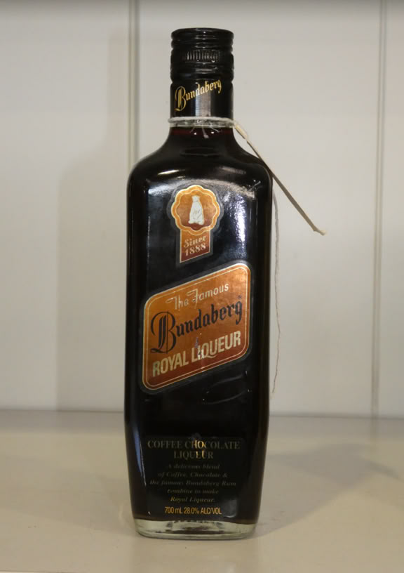 A dark glass bottle with a label reading "Bundaberg Royal Liqueur" on a light-colored surface.