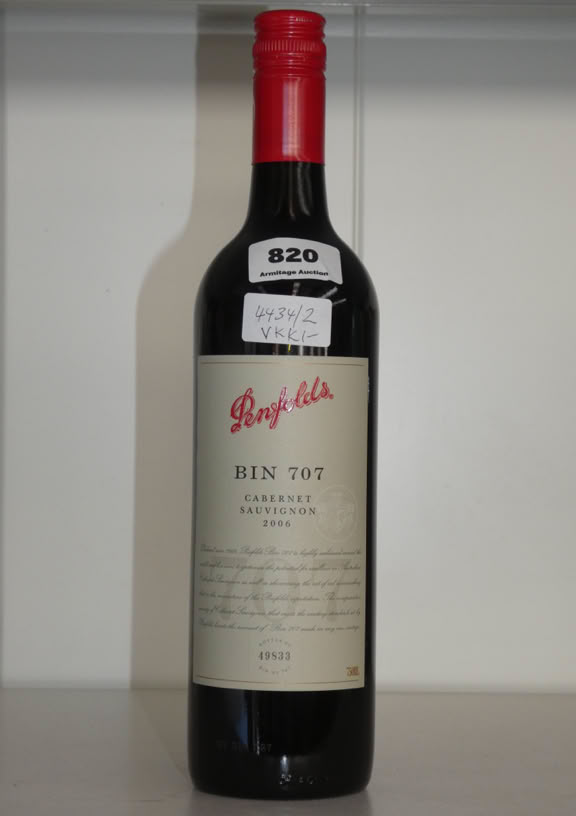 A bottle of Tall Ships rum with a cork stopper, featuring a label with a ship illustration and a metal cannon decoration at the bottom. The bottle has a light brown liquid inside and is marked with the number 636.